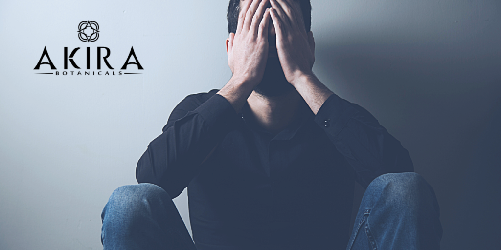 A man with his hands on his face dealing with anxiety.